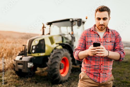 Farmer using smartphone for controlling organic harvest - modern agriculture concept