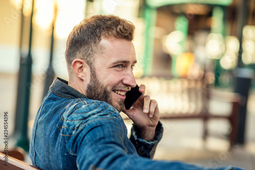 Young man sitting and talking over the phone