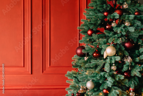 decorated christmas tree near red wall
