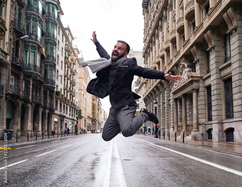 Un chico joven salta en el medio de la calle Via Laietana de Barcelona en un día lluvioso photo