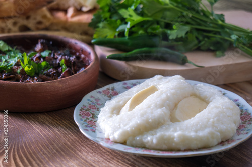 Georgian cuisine - ghomi and kuchmachi with parsley on the wooden table