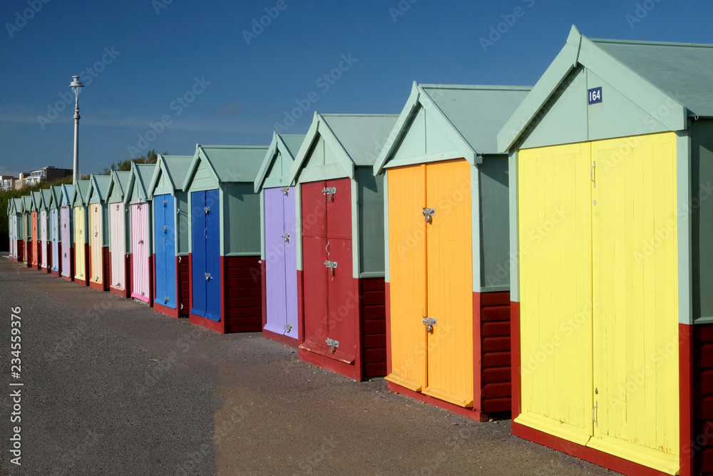sixteen multicoloured beach huts in a row