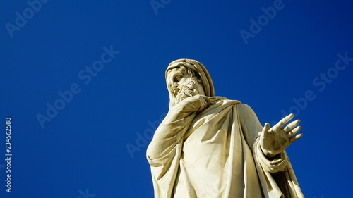 White marble philosopher statue seen from below, in a public square in Rome photo