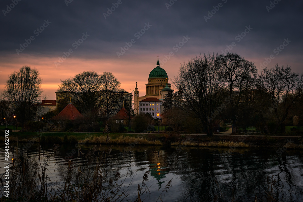 Obraz premium Sonnenuntergang über dem Nuthe-Park in Potsdam mit Blick auf die Nikolaikirche