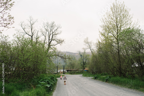 Two children riding on their scooters