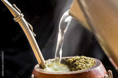Water served into steaming yerba mate infusion 