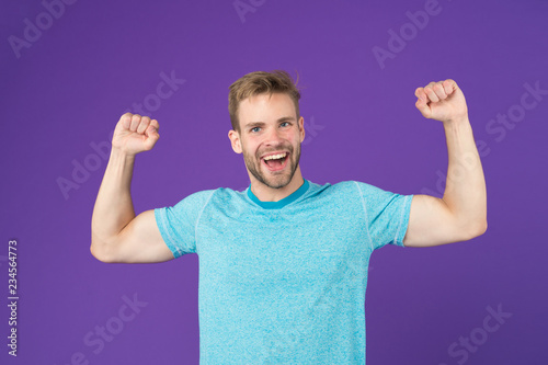 Strong and full of energy. Man strong handsome unshaven guy on violet background. Masculinity concept. Man with muscular arms confident and strong. Does having muscular body make you more confident photo