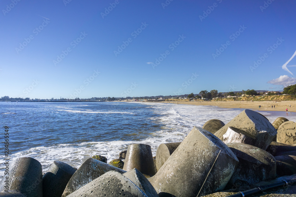 Concrete blocks protecting the jetty of Santa Cruz Harbor, sandy beach in the background, California Concrete blocks protecting the jetty of Santa Cruz Harbor, sandy beach in the background, California