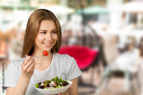 Attractive caucasian woman with salad  on background