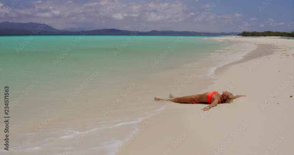 Aerial view of a woman lyingon the beach on a desert island. Concept of: travel, honeymoon, holiday and relaxation. Aerial view of a woman lyingon the beach on a desert island. Concept of: travel, honeymoon, holiday and relaxation.