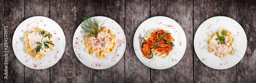 Set of pasta from worldwide cuisines. Fettuccine pasta meat, seafood pasta with shrimp, oysters, octopus, cheese and herbs, in bowl on rustic wooden background. Top view. Italian cuisine. Top view