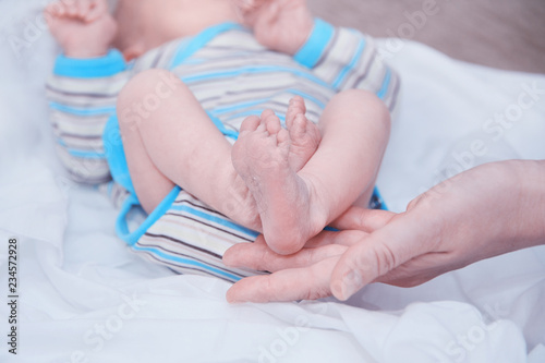 The tiny feet of the newborn in the hands of the mother. The concept of motherhood and child protection. Close-up. Copy space