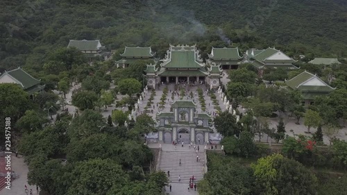 2K Aerial top view of Linh Ung pagoda in Danang Vietnam.  Ancient asian temple with the stairs and green coloured roofs among tropical trees.   photo