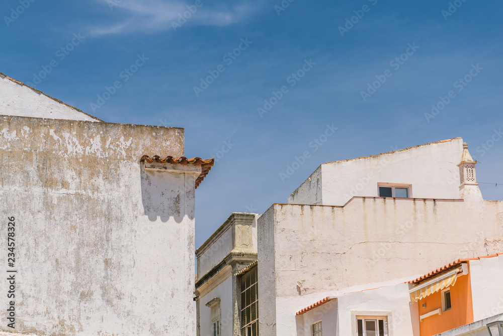 White buildings and angled rooflines of old buildings in the historical city center of Tavira, Portugal