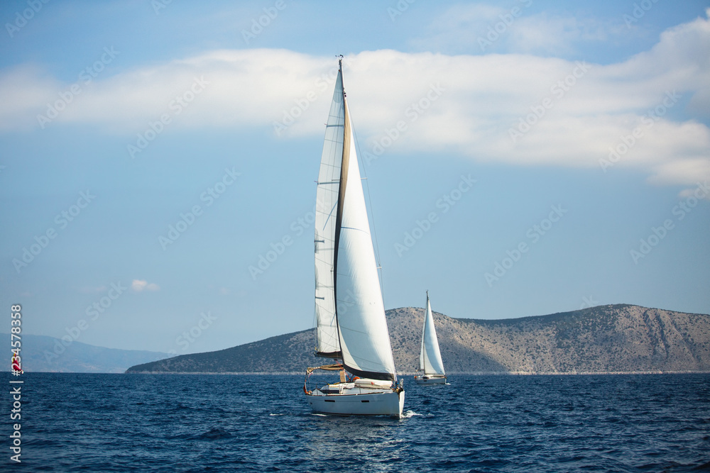 Sailing luxury boats participate in yacht regatta in the Aegean Sea in Greece.