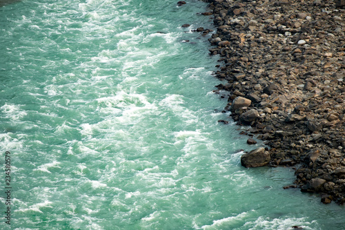 Spectacular view of the sacred Ganges river flowing through the green mountains of Rishikesh, Uttarakhand, India.