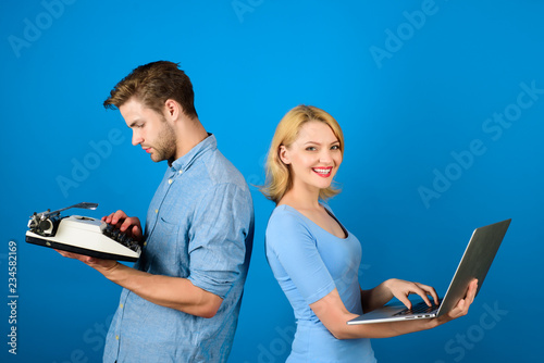 Future and past. Woman with laptop. Man with typewriter. Old fashioned against modern. Outdated against new. Different generations. Technical progress. Man writes on typewriter&woman working on laptop photo