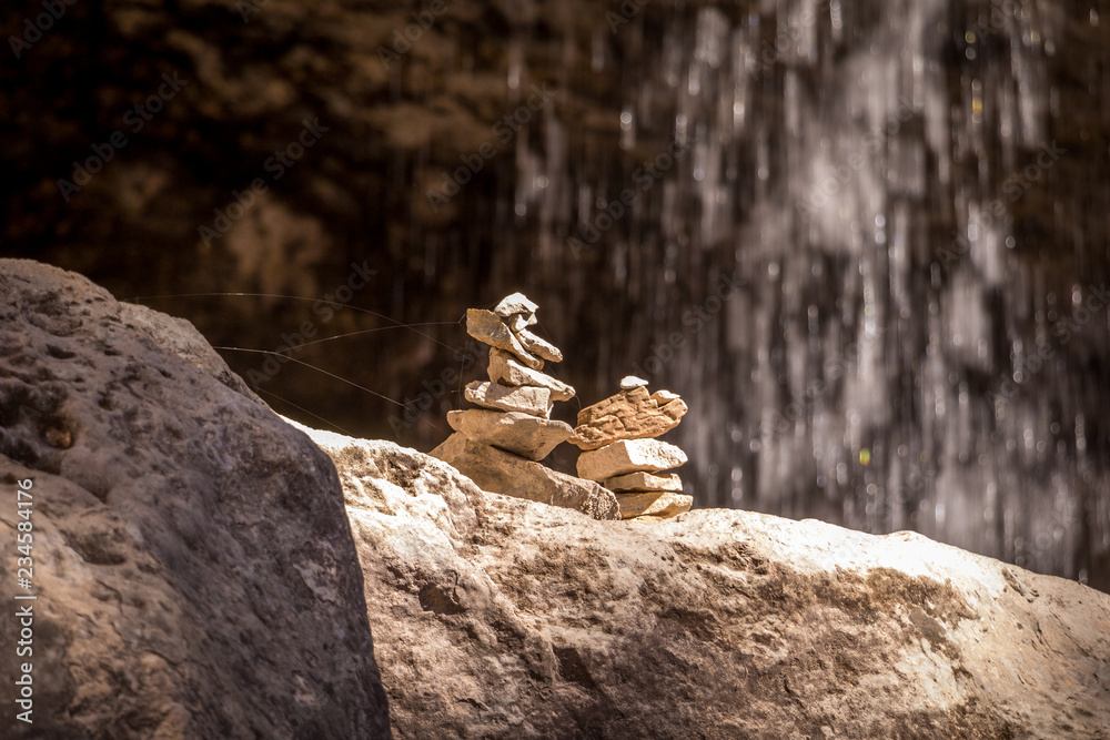 Obraz premium Two Cairns by a Water Fall