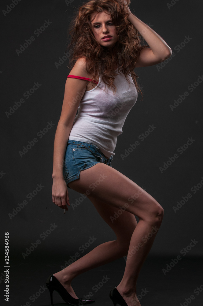 Young woman in wife beater and blue jeans shorts Young woman in wife beater and blue jeans shorts