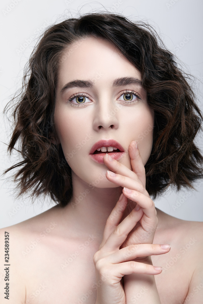 Closeup beauty portrait of young woman with hands near face Closeup beauty portrait of young woman with hands near face