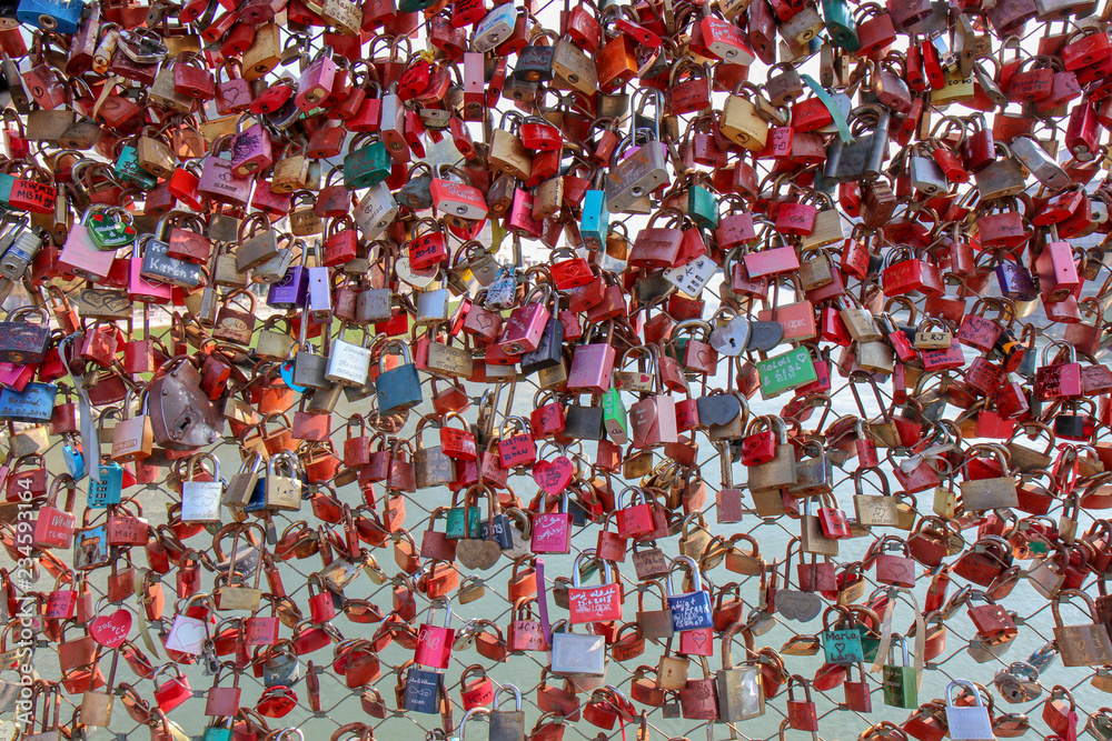 Closed fastened metal wedding locks fastened on bridge in of tourist attraction in Pedestrian Bridge At Salzburg, Austria