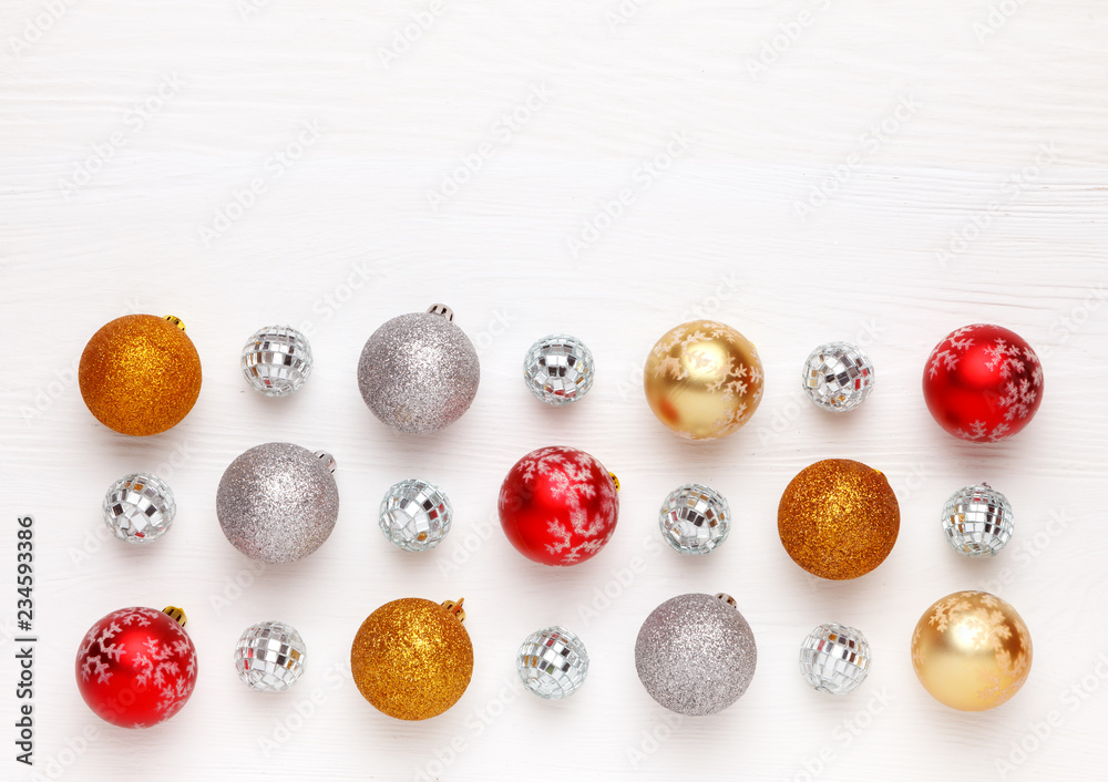 Pattern of Christmas toys (colorful balls) on white wooden background.
