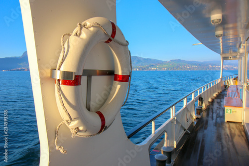 red and white safety torus or lifebuoy hanging on the boat