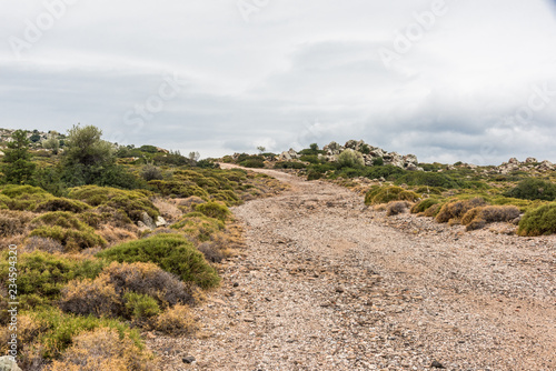 Unpaved gravel road going  up the hill