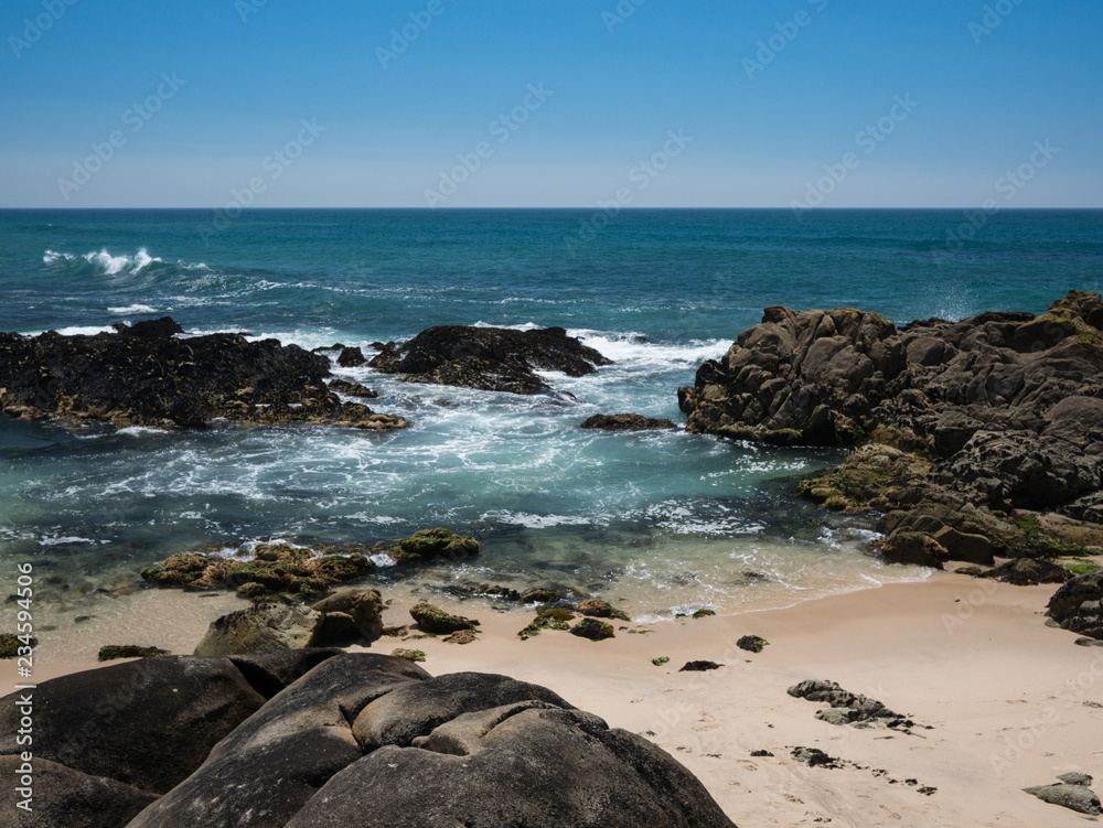 Beautiful rocky beach on sunny day with clear blue water and blue cloudless sky in Vila do Conde, Porto region, Portugal Beautiful rocky beach on sunny day with clear blue water and blue cloudless sky in Vila do Conde, Porto region, Portugal