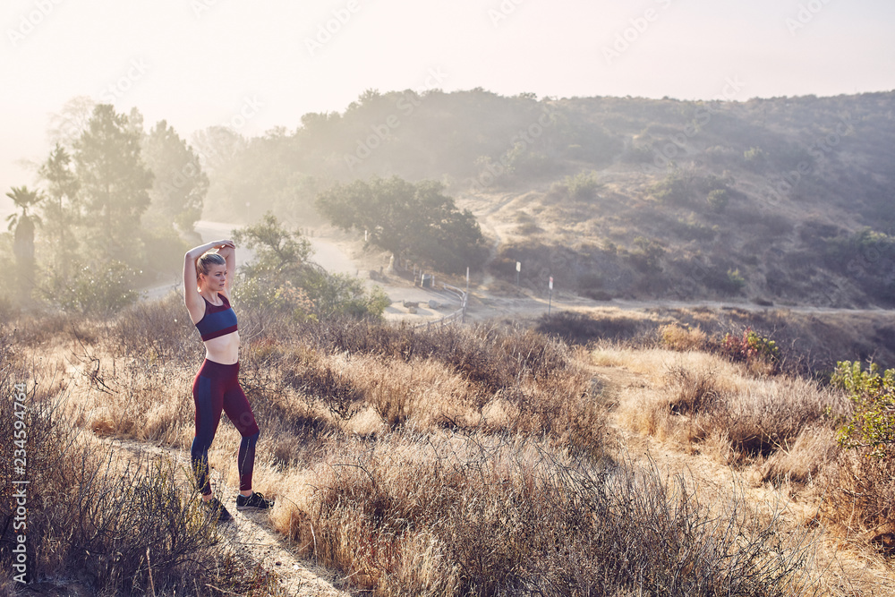 Beautiful Caucasian White Woman Runs on a Trail in the Morning Sunlight