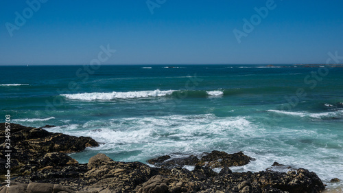 Beautiful rocky beach on sunny day with clear blue water and blue cloudless sky in Vila do Conde, Portugal