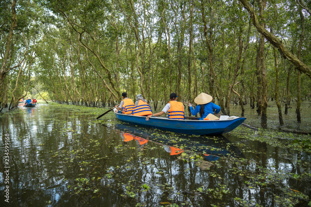 Tourism rowing boat in cajuput forest in floating water season in Mekong delta, Vietnam