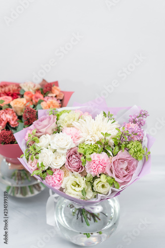 European floral shop. Two Bouquet Mixed beautiful flowers on wooden gray table. Nice garden flowers in the arrangement , the work of a professional florist.