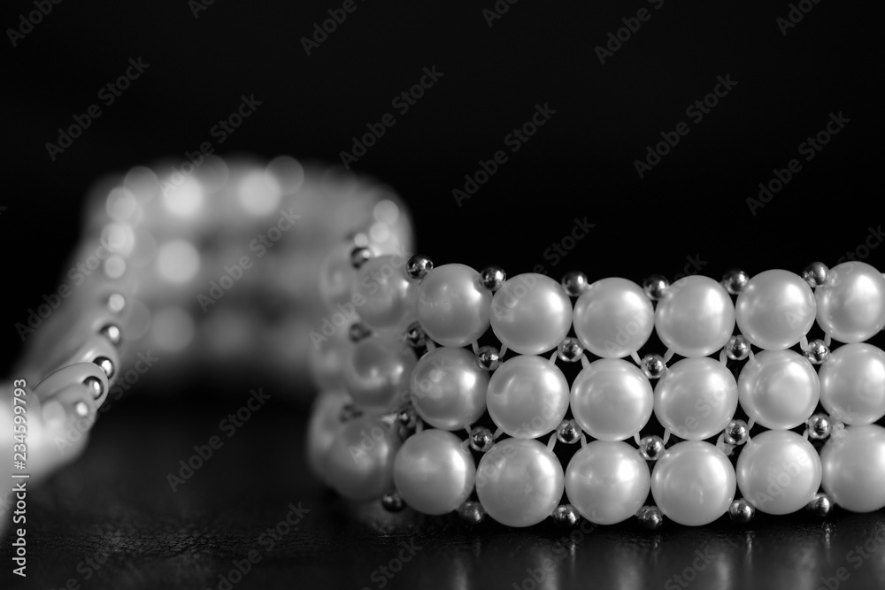 White pearl necklace on a dark background close up. Black and white White pearl necklace on a dark background close up. Black and white