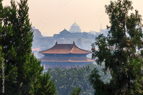 The temple roof and Beijing city skyline from the top of Buddhist Yong'An (Temple of Everlasting Peace) in Beihai Park, Beijing, China photo