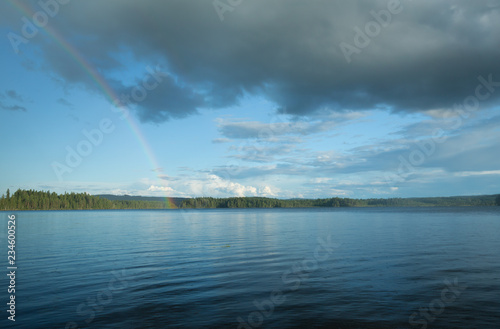 Rainbow and rain over a swedish lake a summers day © Henrik Larsson