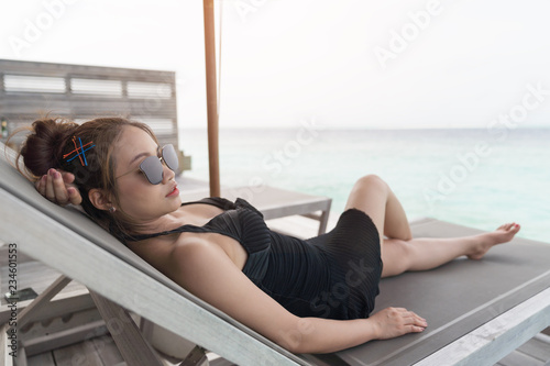 Asian sexy woman sitting on bedchair beach. photo