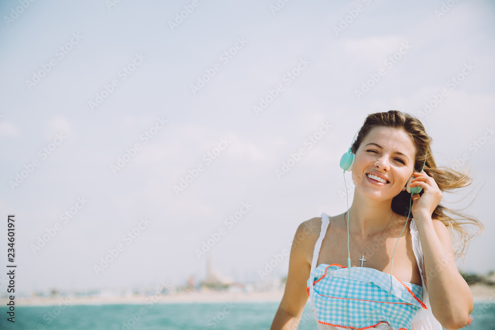Beautiful sexy girl walking on the sandy beach at summer and listening to music.. Beautiful sexy girl walking on the sandy beach at summer and listening to music..