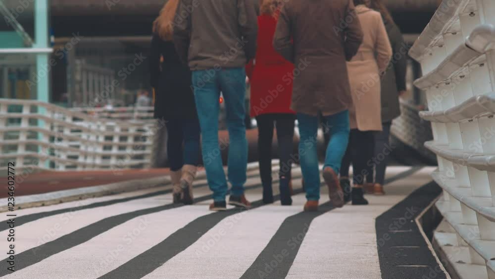 Group Of People Strolling On A Designated Modern Striped Pedestrian Walkway In Amsterdam. Group Of People Strolling On A Designated Modern Striped Pedestrian Walkway In Amsterdam.