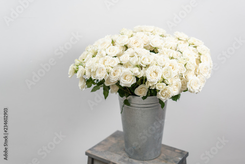 Big luxury bright bouquet on wooden table. Garden spray roses of white color . bouquet in metal vase