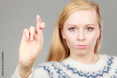 Teenage blonde woman making promise gesture