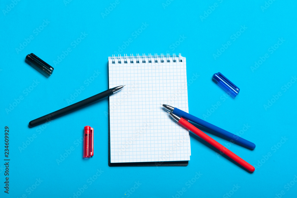 Top view workspace mockup on blue background with notebook, pen Top view workspace mockup on blue background with notebook, pen