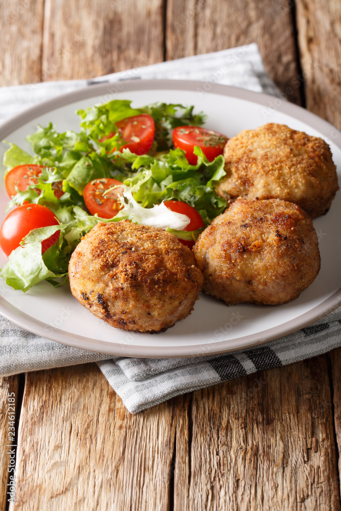 Danish pork patty kabonader or krebinetter with fresh salad close-up on a plate. vertical Danish pork patty kabonader or krebinetter with fresh salad close-up on a plate. vertical