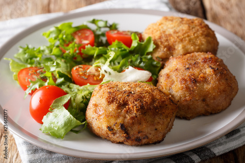 Danish food: traditional breaded pork Patties Karbonader served with fresh salad close-up on a plate. horizontal