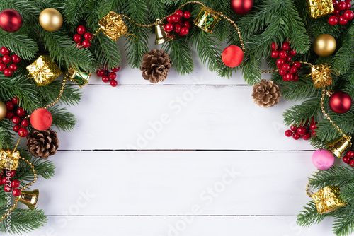 Christmas background concept. Top view of Christmas gift box red balls with spruce branches, pine cones, red berries and bell on old wooden background.