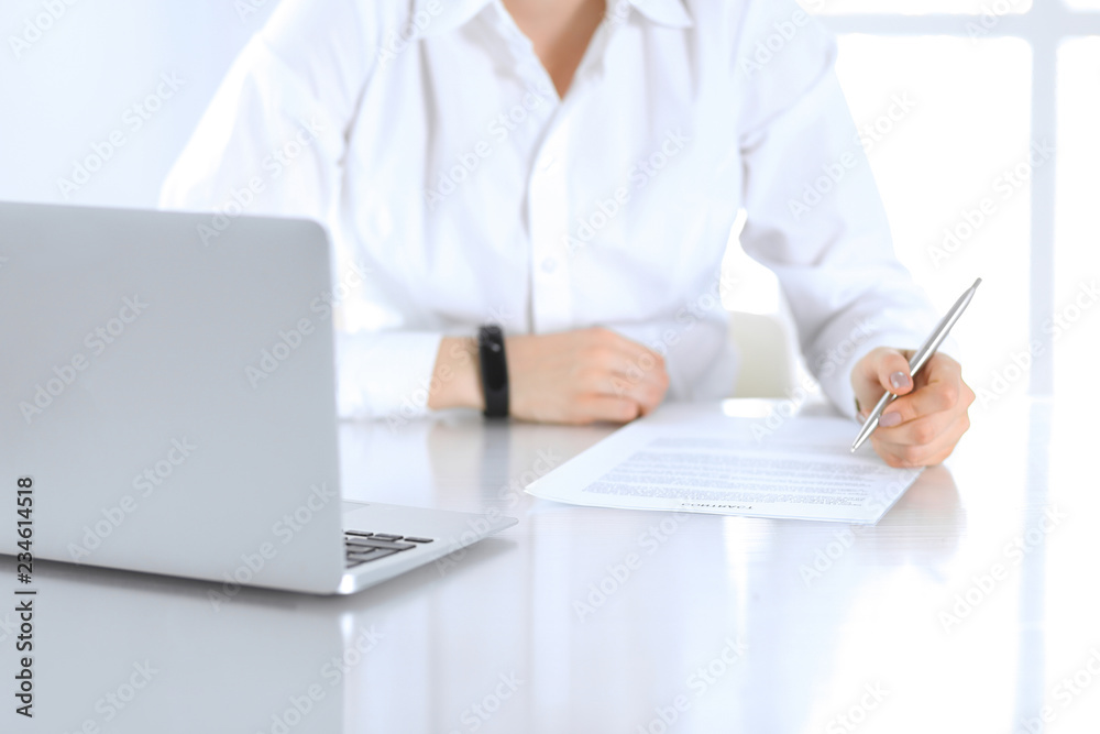 Close-up of female hands with pen over document, business concept. Lawyer or business woman at work in office Close-up of female hands with pen over document, business concept. Lawyer or business woman at work in office