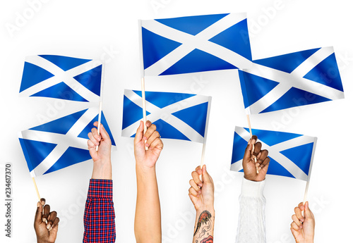 Hands waving flags of Scotland photo