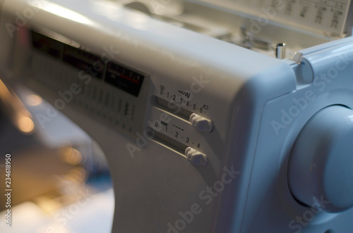  master sews fabric product with a sewing machine on a dark background