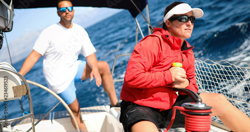 Attractive strong woman sailing with her boat