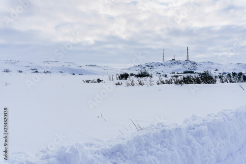 radio cell phone towers on a hill covered with snow in winter in a remote northern village beyond the Arctic Circle